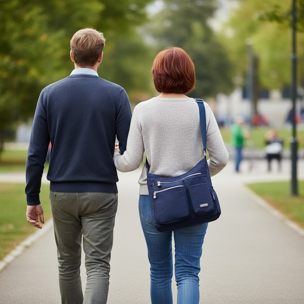 ZenZon Nordic navy blue nylon crossbody bag with multiple zipper pockets worn by a woman walking in a park.