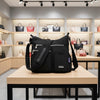 ZenZon Nordic black nylon crossbody bag with multiple zippered pockets and adjustable strap in a retail store.